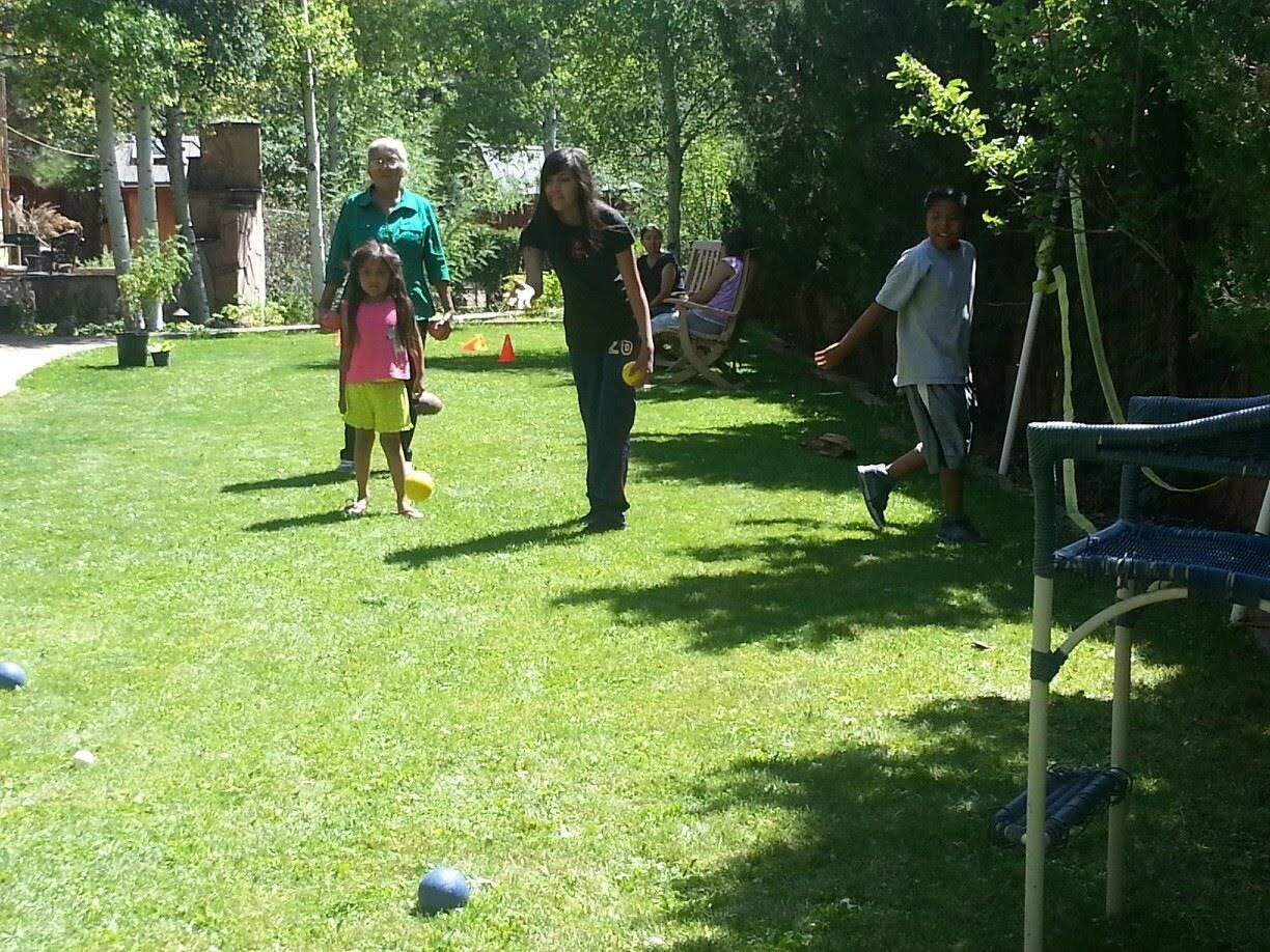 A grandmother and children playing on the lawn of the garden